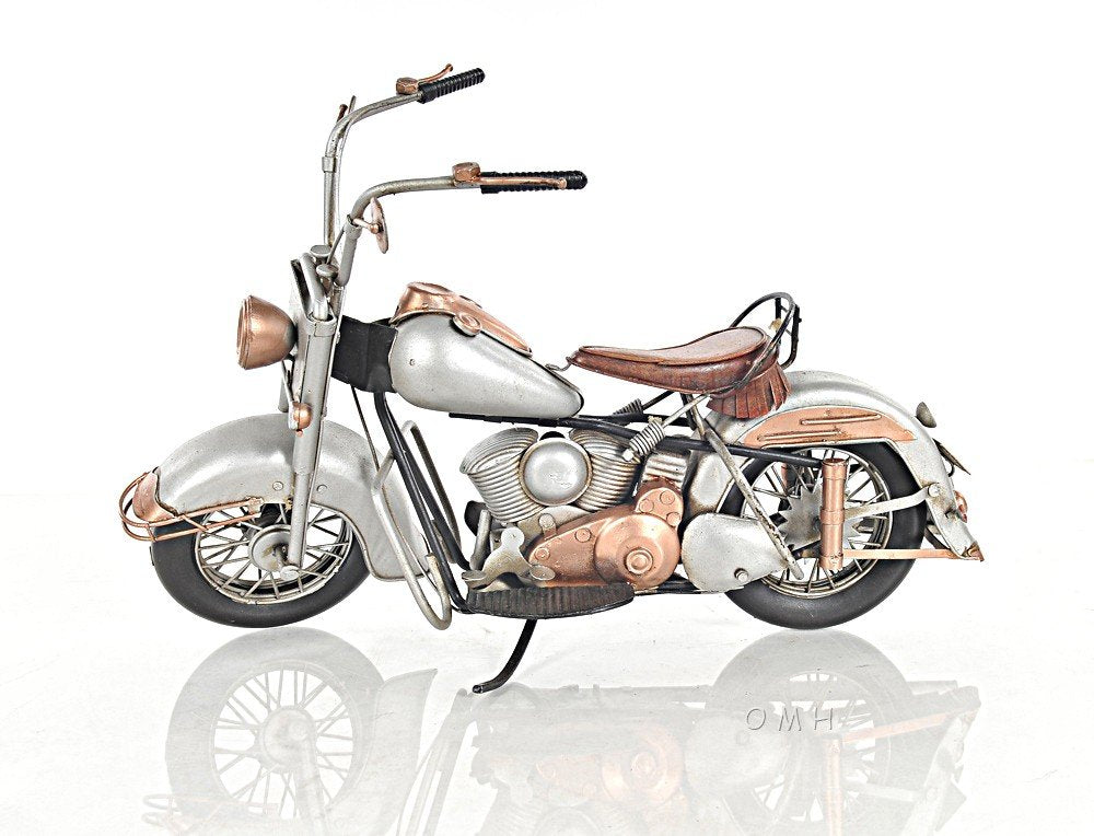 Decorative vintage motorcycle model in silver and copper tones, with leather seat and spoked wheels.