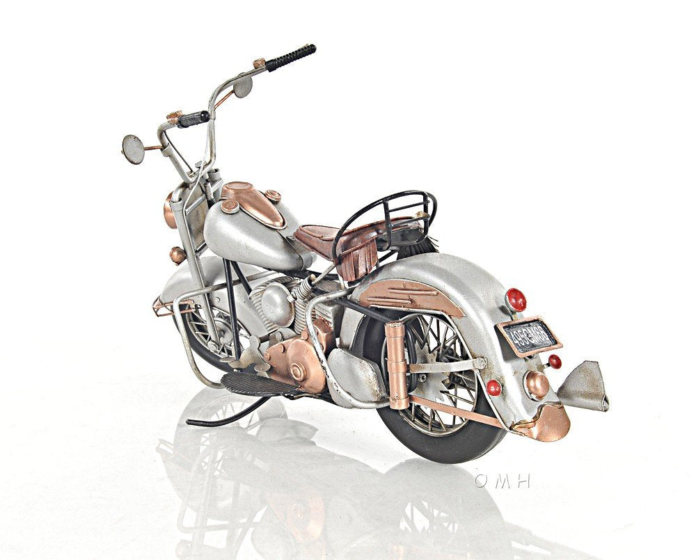 Vintage silver motorcycle with copper accents, leather saddle seat, chrome detailing and rear rack.