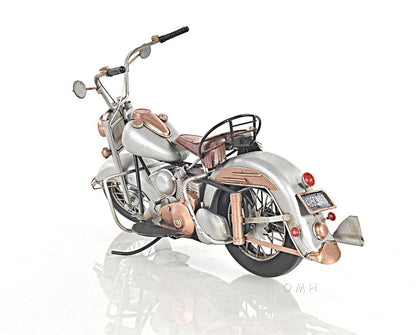Vintage silver motorcycle with copper accents, leather saddle seat, chrome detailing and rear rack.