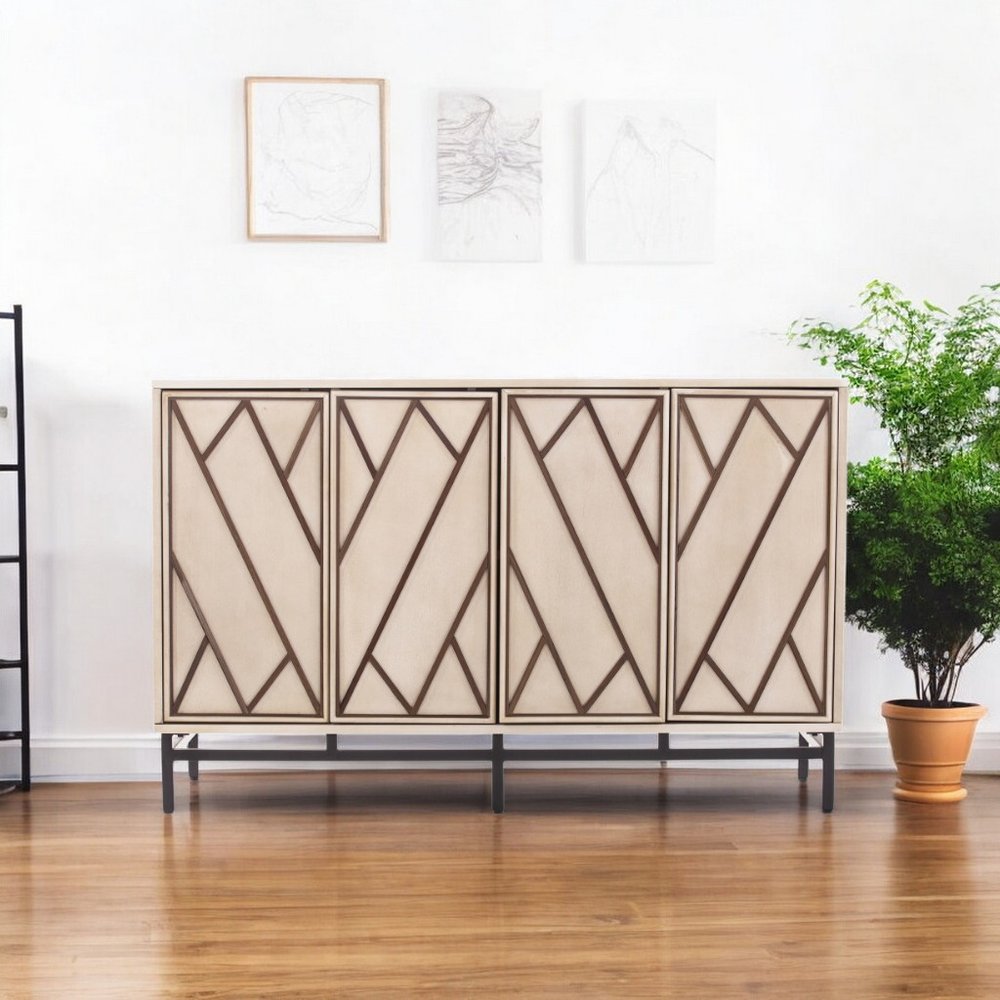 Light wood sideboard with dark geometric diagonal panels, four doors, metal base, in a bright living room.