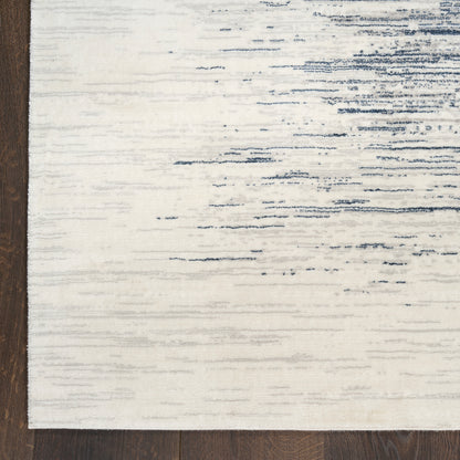 Ivory area rug with subtle blue streaks and distressed pattern, rectangular, on dark wood floor.