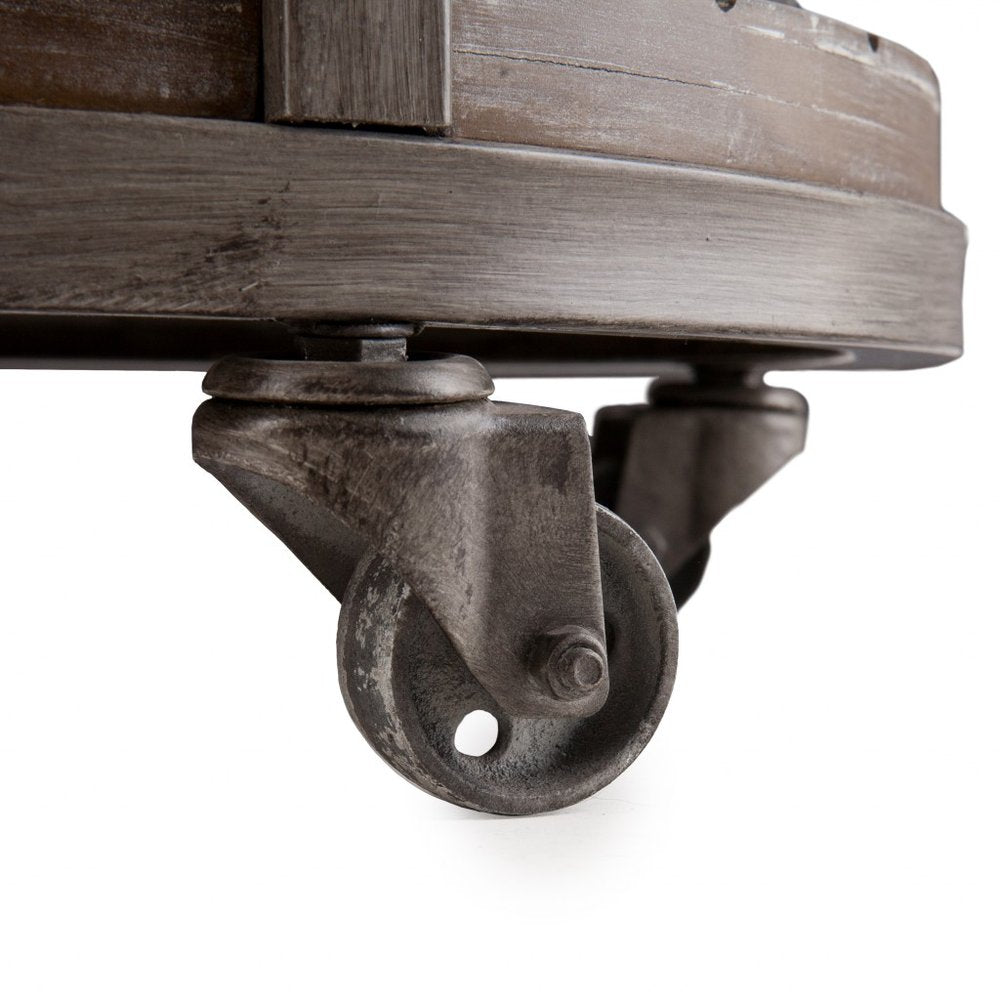 Rusty metal swivel caster under a curved wooden barrel-style platform; vintage furniture cart wheel.