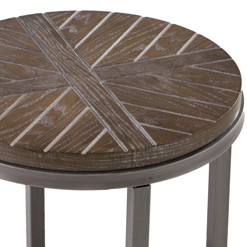 Round distressed brown wood table top with intersecting plank pattern on dark legs; rustic coffee/side table.