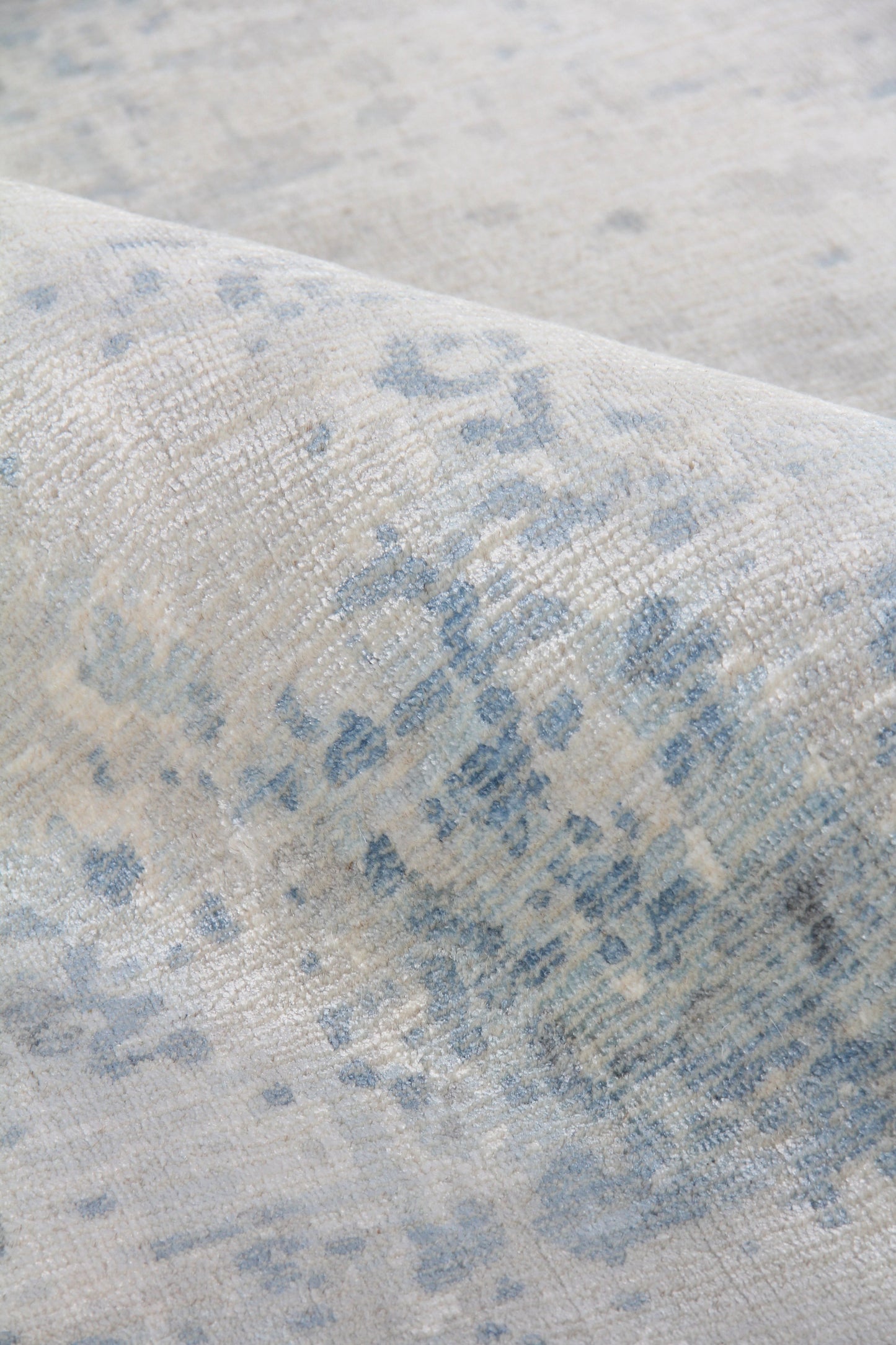 Beige & blue abstract patterned rug with a soft woven texture; modern distressed style.