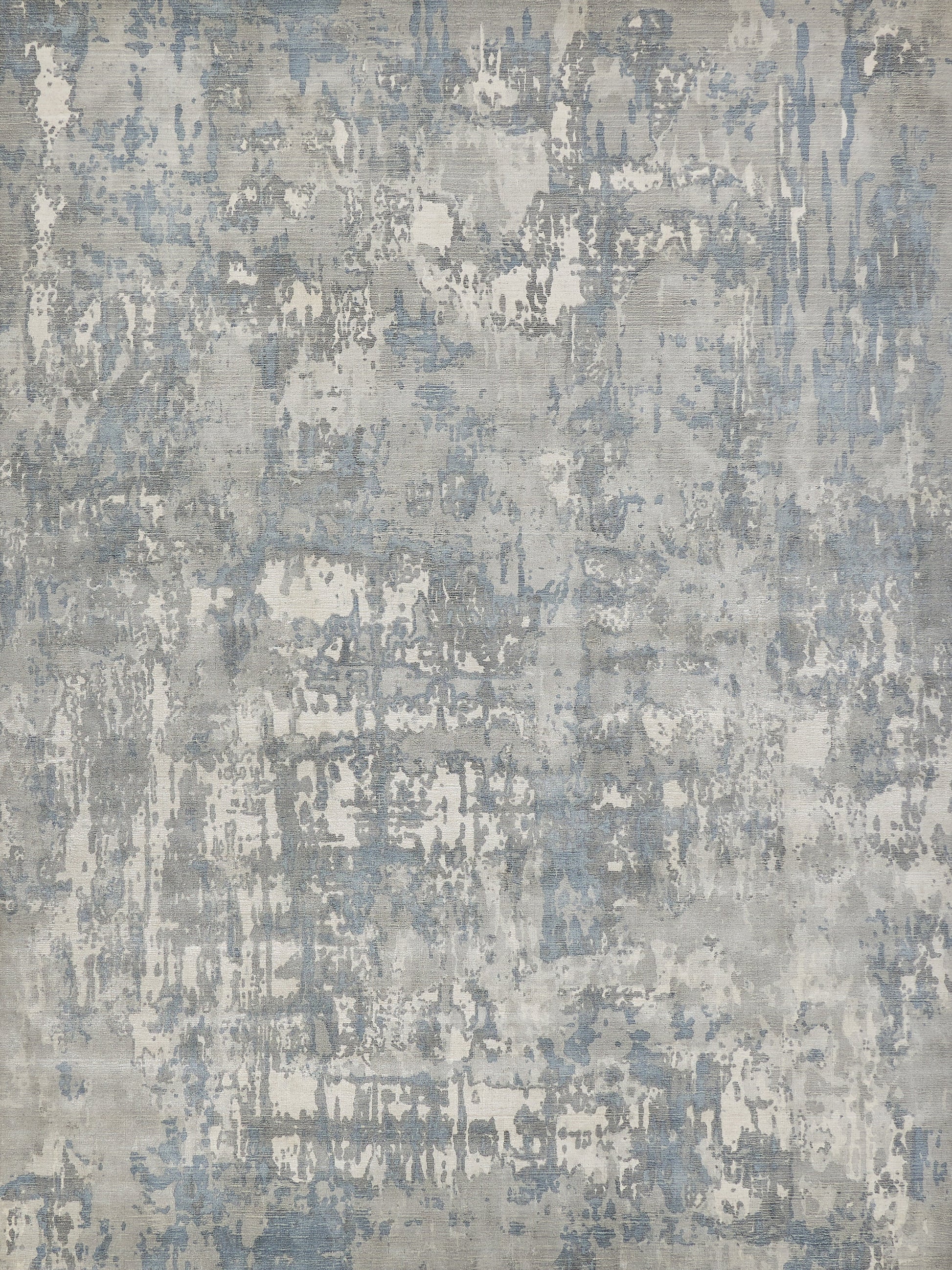 Abstract distressed gray-blue area rug with mottled pattern and worn, painterly texture.