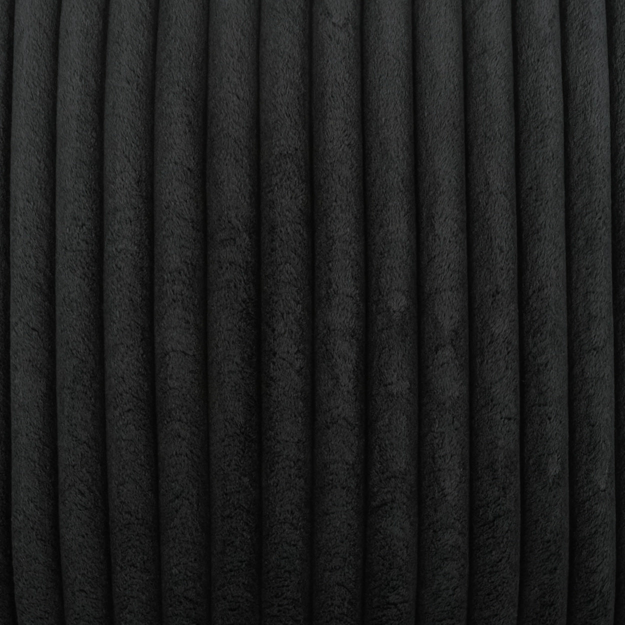Black pillow with solid jet color and soft, textured surface.