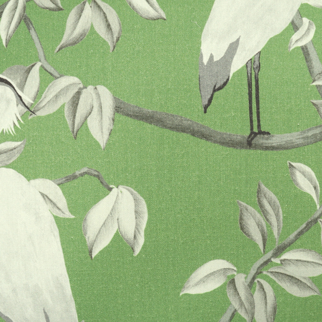 Green fabric with white and gray cranes perched on branches and leaves in a botanical pattern.