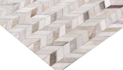 Neutral mosaic leather rug with hand-stitched patchwork in cream, beige & taupe featuring geometric blocks.