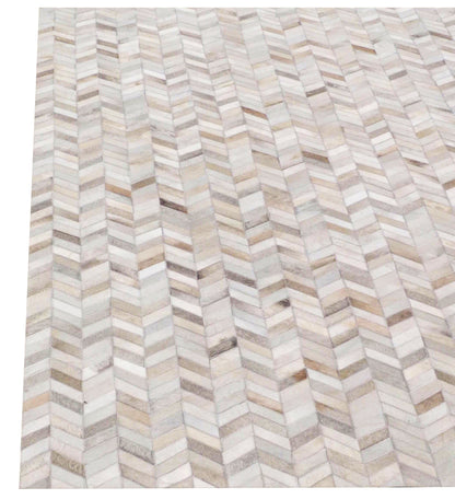 Neutral mosaic leather rug with ivory, beige & gray leather tiles in a patchwork design.