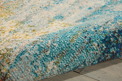 Close-up of a multicolor shag rug with blue, teal, and yellow tufted pile on a wooden floor.