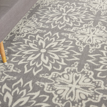Grey area rug featuring large white floral medallion motifs in a damask-style pattern.