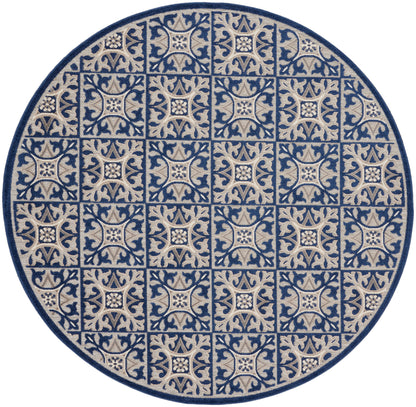 Round rug featuring blue and beige tile-like arabesque squares with floral centers, woven texture