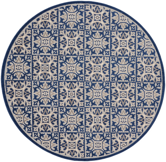 Round rug featuring blue and beige tile-like arabesque squares with floral centers, woven texture