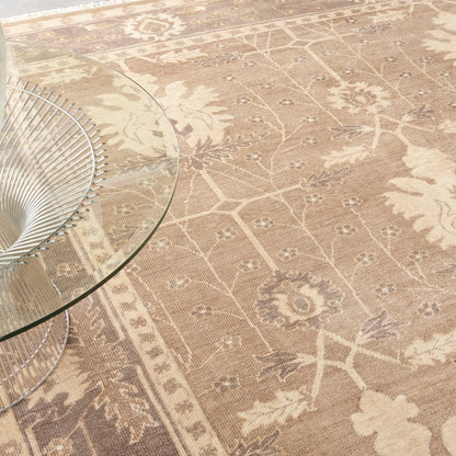 Beige floral patterned area rug with a round glass coffee table and a metal wire base.