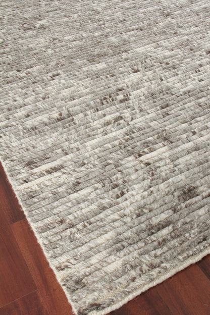 Grey and cream hand-knotted rug with dense pile on dark wood floor