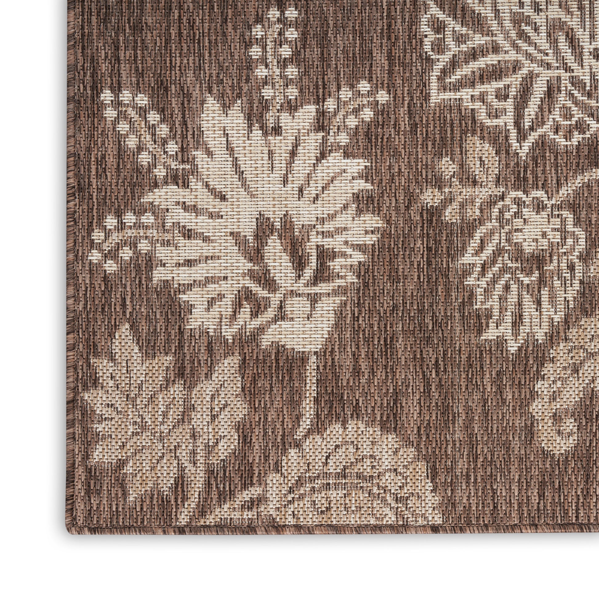 Brown woven rug with beige floral jacquard pattern and textured surface.