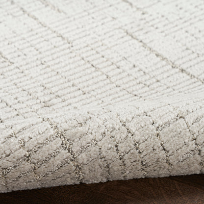 Cream textured rug with diamond pattern, low-pile loop weave, close-up edge on dark wooden floor