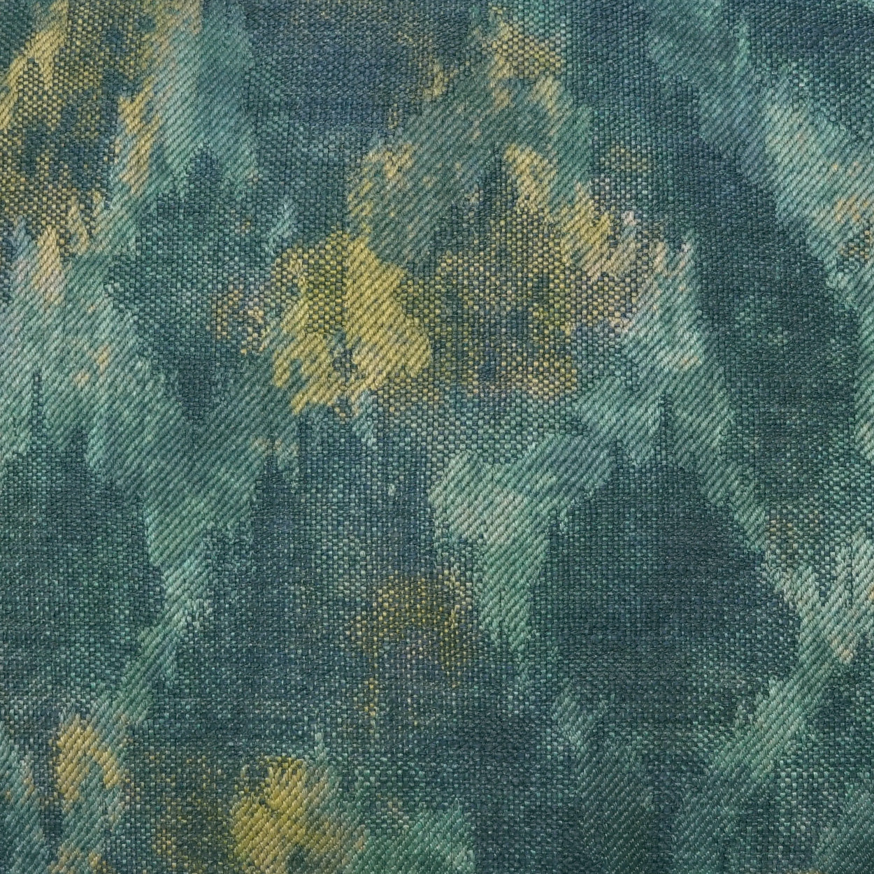 Abstract teal, blue and green woven fabric with yellow accents; textured upholstery-style textile.