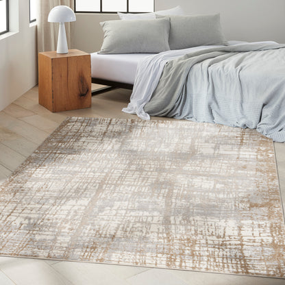 Light gray bedding, beige-taupe abstract rug on pale wood floor; wooden nightstand with white dome lamp.