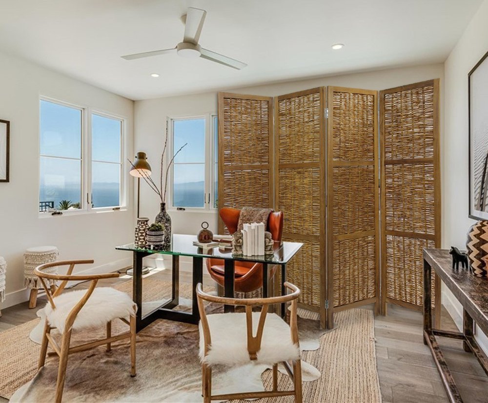 Bright coastal home office with glass-top desk, light wood rattan chairs, brown folding four-panel room divider, and ocean view.