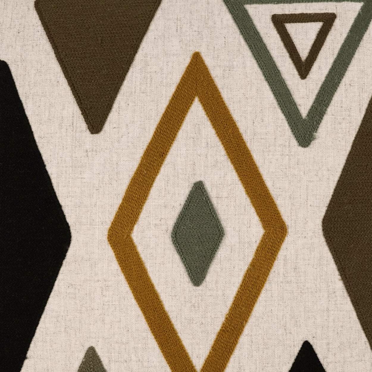 Beige fabric featuring geometric diamond and triangle motifs in mustard, olive, and brown.