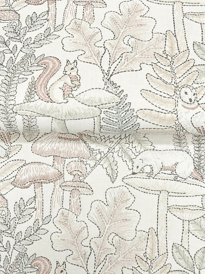 Embroidered, line-drawn woodland pattern on fabric with squirrels, mushrooms and leaves in soft beige and taupe.