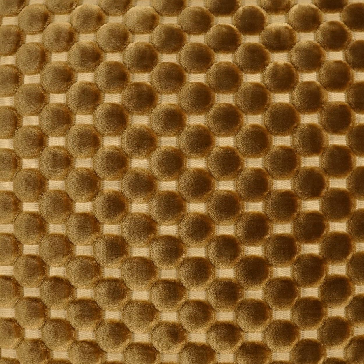 Golden-brown bubble-textured fabric with raised circular dots in a grid pattern.