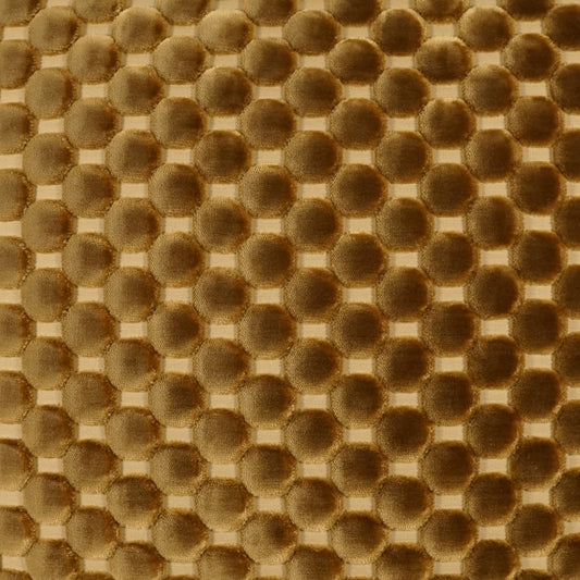 Golden-brown bubble-textured fabric with raised circular dots in a grid pattern.