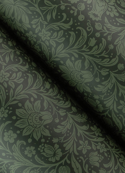 Olive-green floral damask fabric on dark green background, folded to show woven pattern and subtle sheen.
