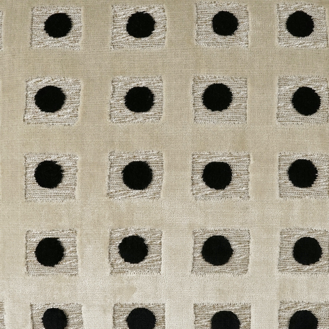 Beige woven fabric with repeating light gray square patches and central black dots; geometric upholstery textile.