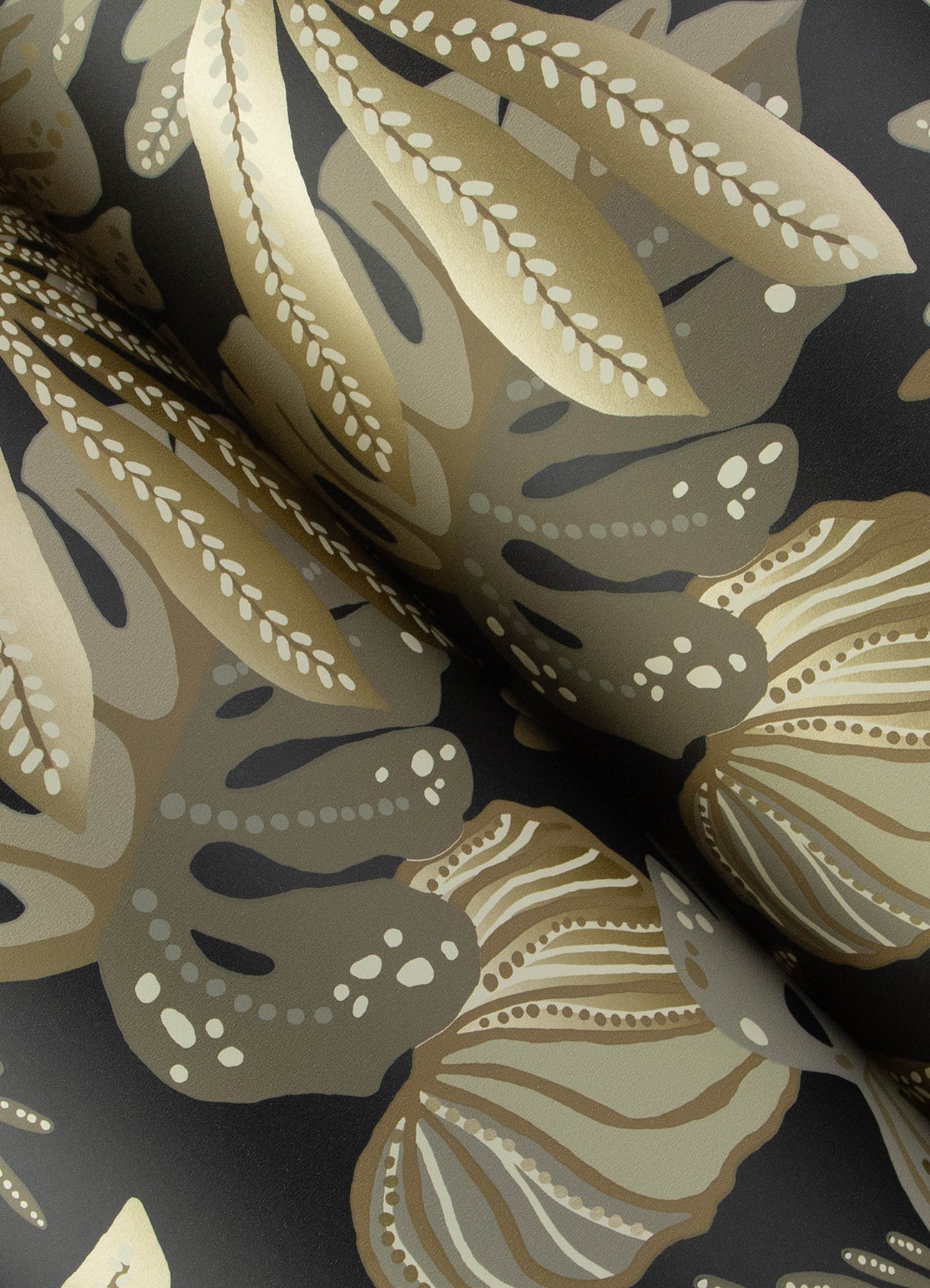 Charcoal and cream wallpaper featuring Alocasia tropical foliage; neutral large leaf motifs, folded.