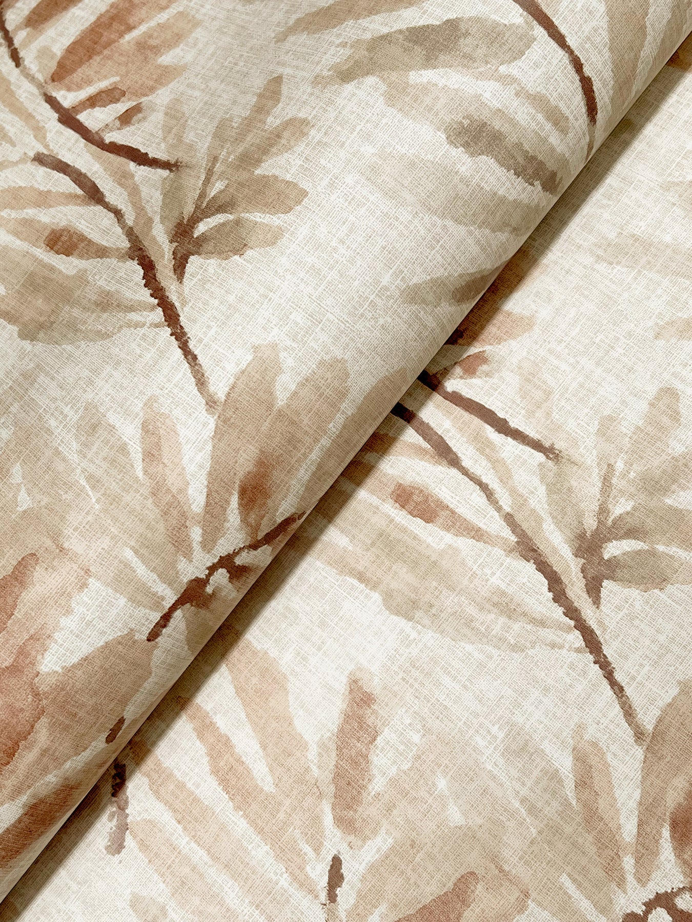 Beige botanical print wallpaper with taupe ferns on light cream background, folded edge.