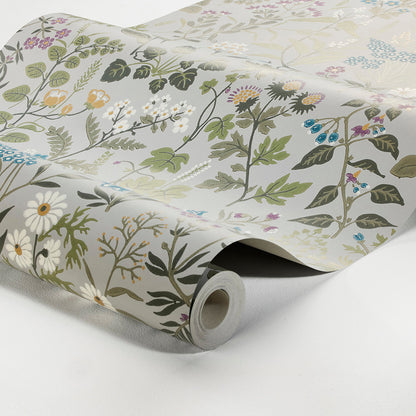 Rolled wallpaper featuring a botanical floral pattern on pale white background; green leaves, daisies, and subtle blooms.