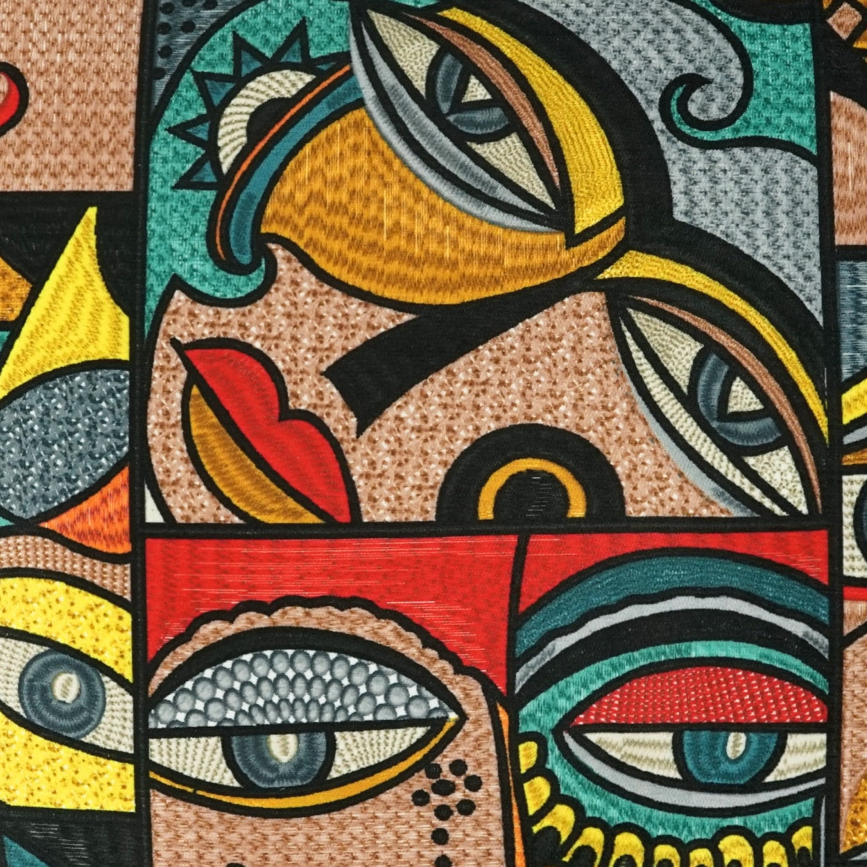Vibrant abstract cubist face collage on fabric; bold black outlines, red, yellow, teal and orange hues in a tapestry style.