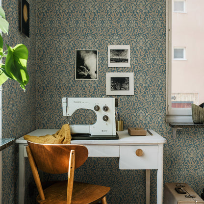 Vintage Husqvarna sewing machine on a white desk with mustard cloth, wooden chair, teal floral wallpaper and framed photos.