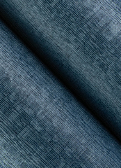 Close-up of dark blue open-weave wallpaper texture with a diagonal fold, showing a textured weave and subtle gradient.