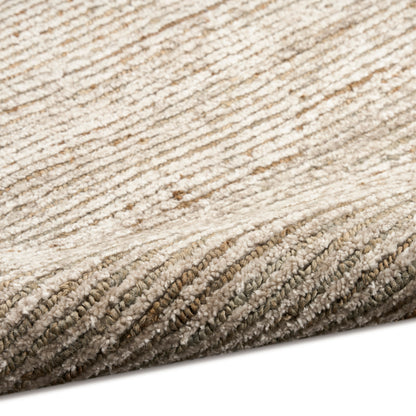Beige textured rug close-up with cream and tan diagonal stripes and folded edge.