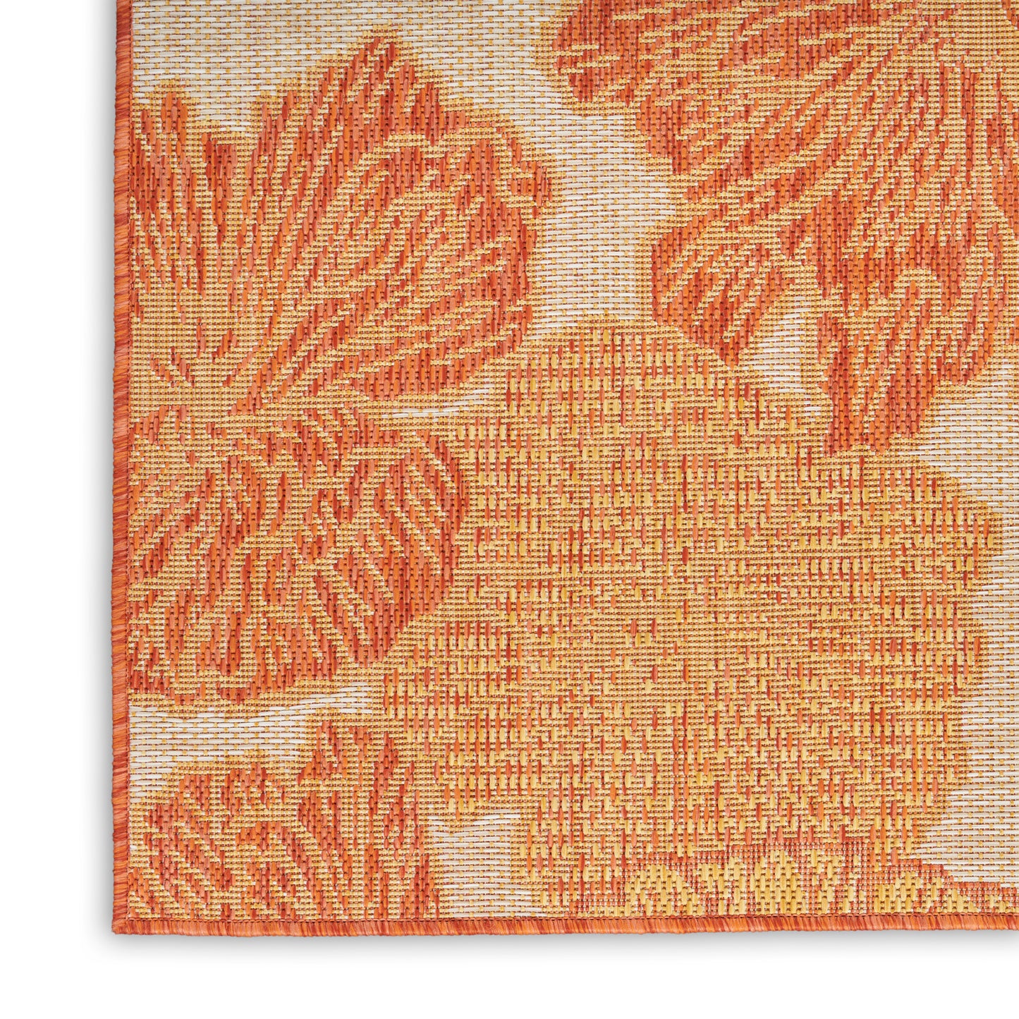 Close-up of orange floral tapestry rug with warm blossom patterns and textured weave; orange edge binding.