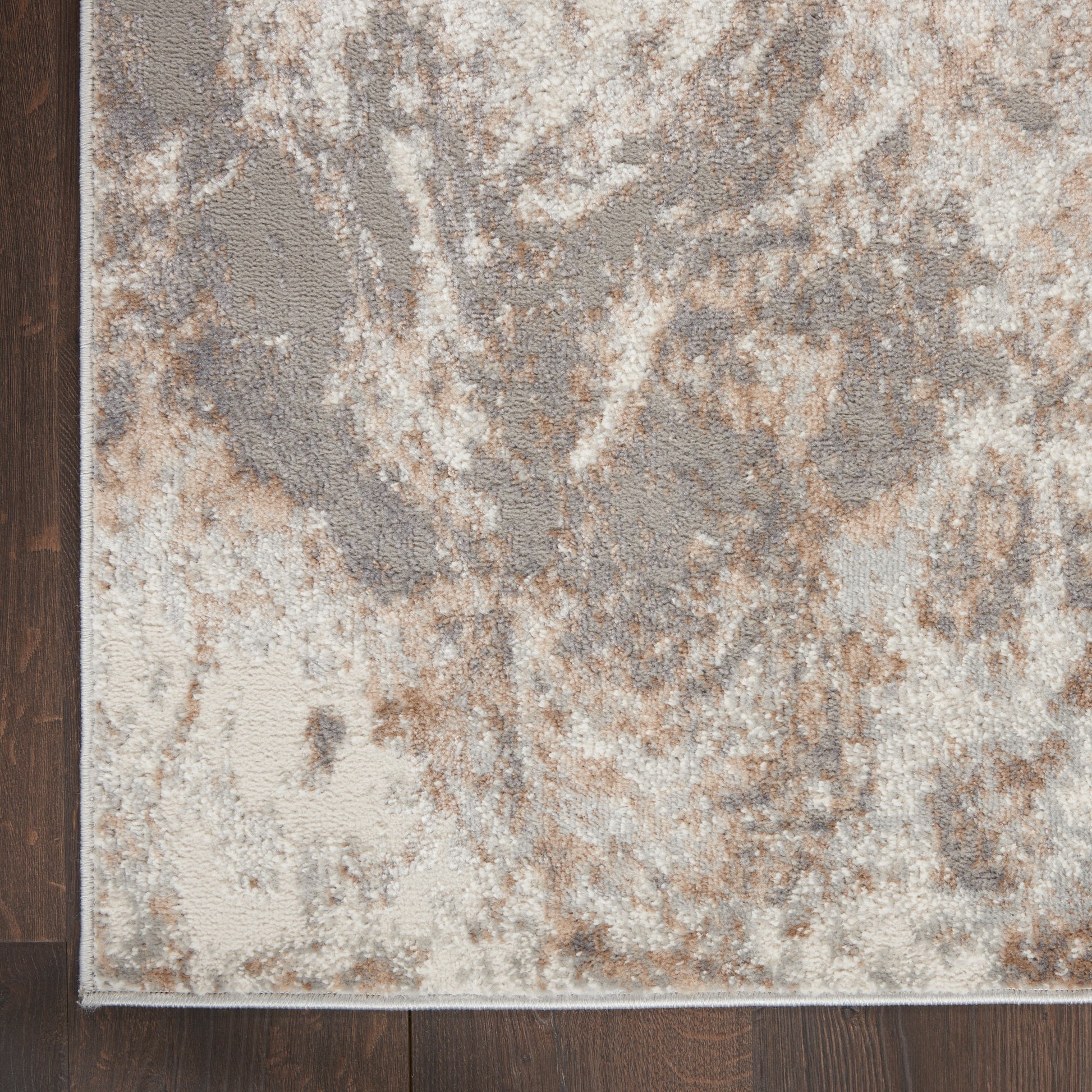 Neutral abstract-pattern area rug in beige, taupe, gray with cream accents; low-pile with a subtle border.