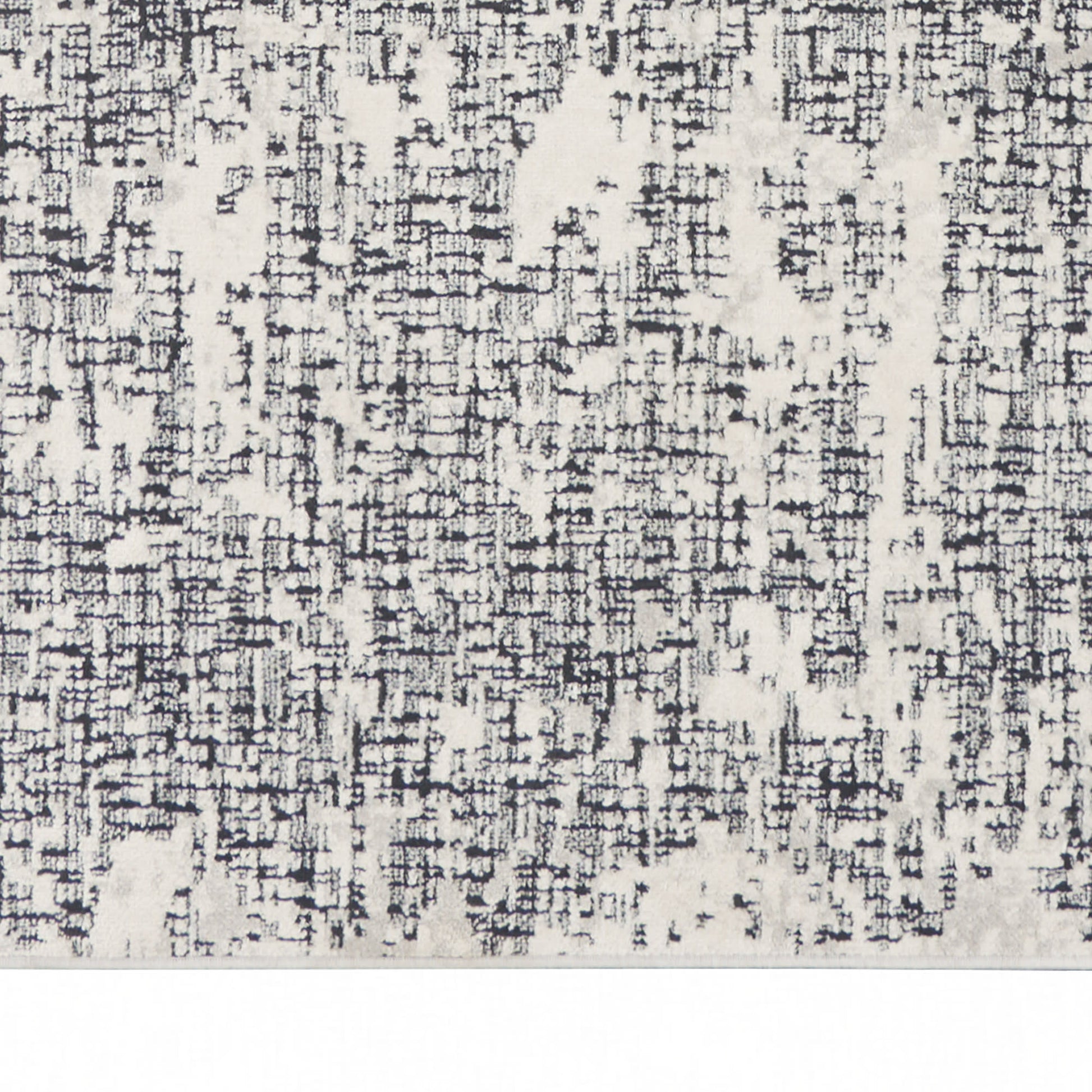Neutral gray and ivory abstract patterned rug with a distressed, blocky texture.