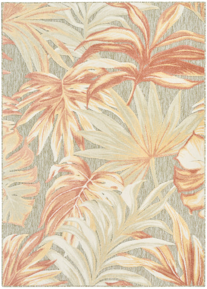 Tropical palm leaf rug in peach, cream and beige on a gray textured background.