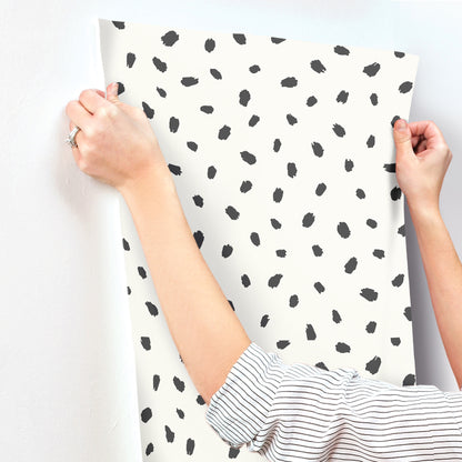 Wallpaper featuring a black animal-spot polka dot pattern on a white background.