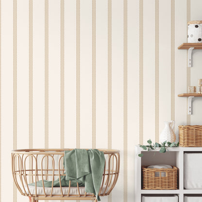 Whimsical light brown bobbin stripe wallpaper with scalloped graphics on a wall.