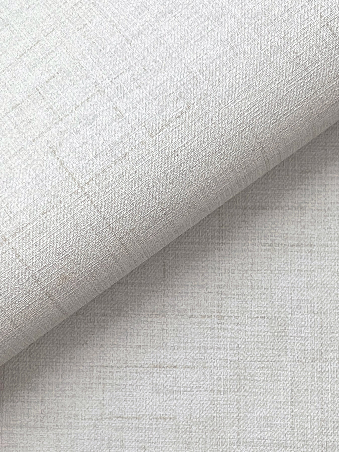 Off-white faux-fabric wallpaper with a subtle woven linen texture, rolled to show the weave.