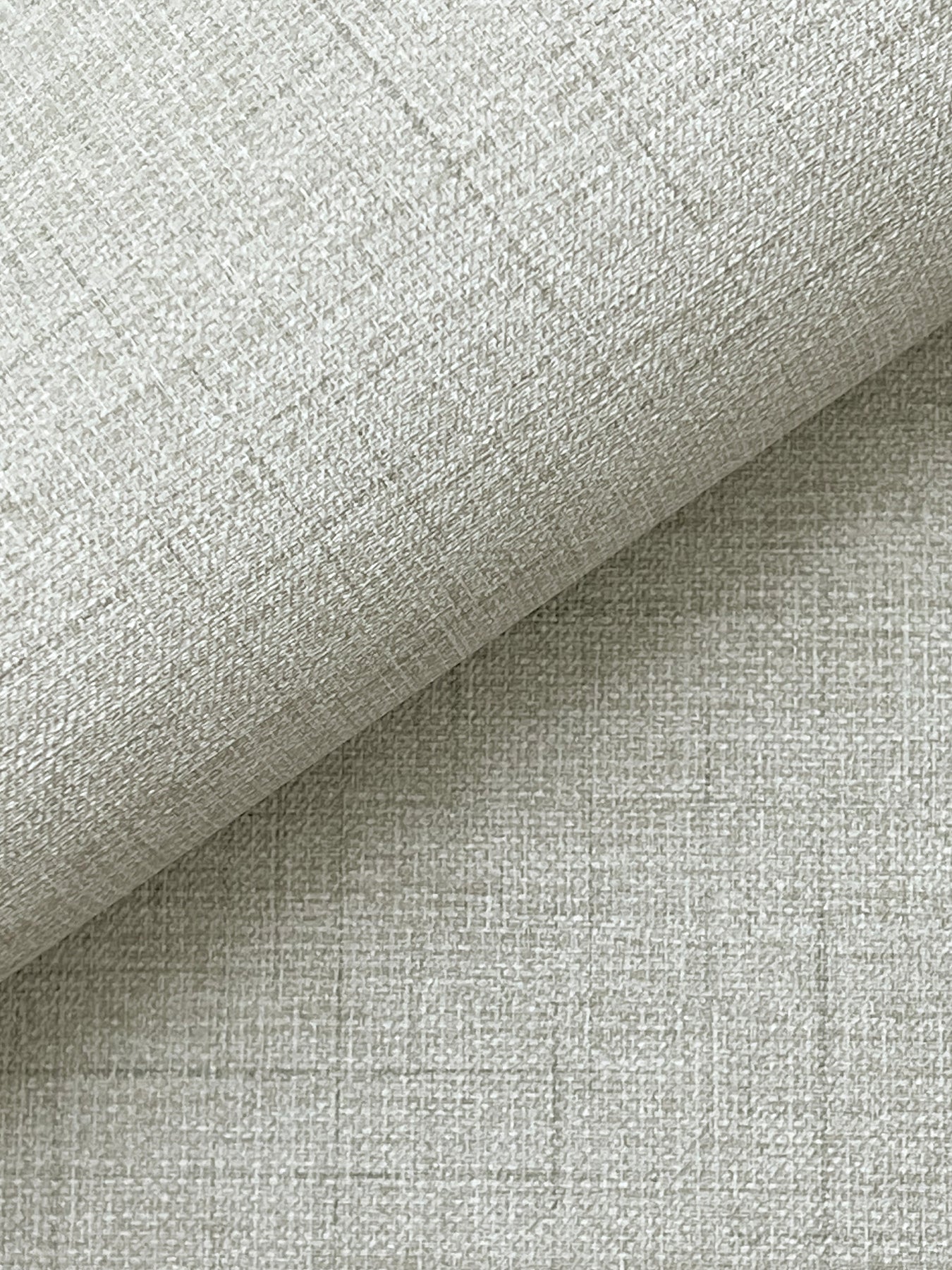 Roll of light gray linen-like wallpaper with a woven texture and subtle grid pattern.