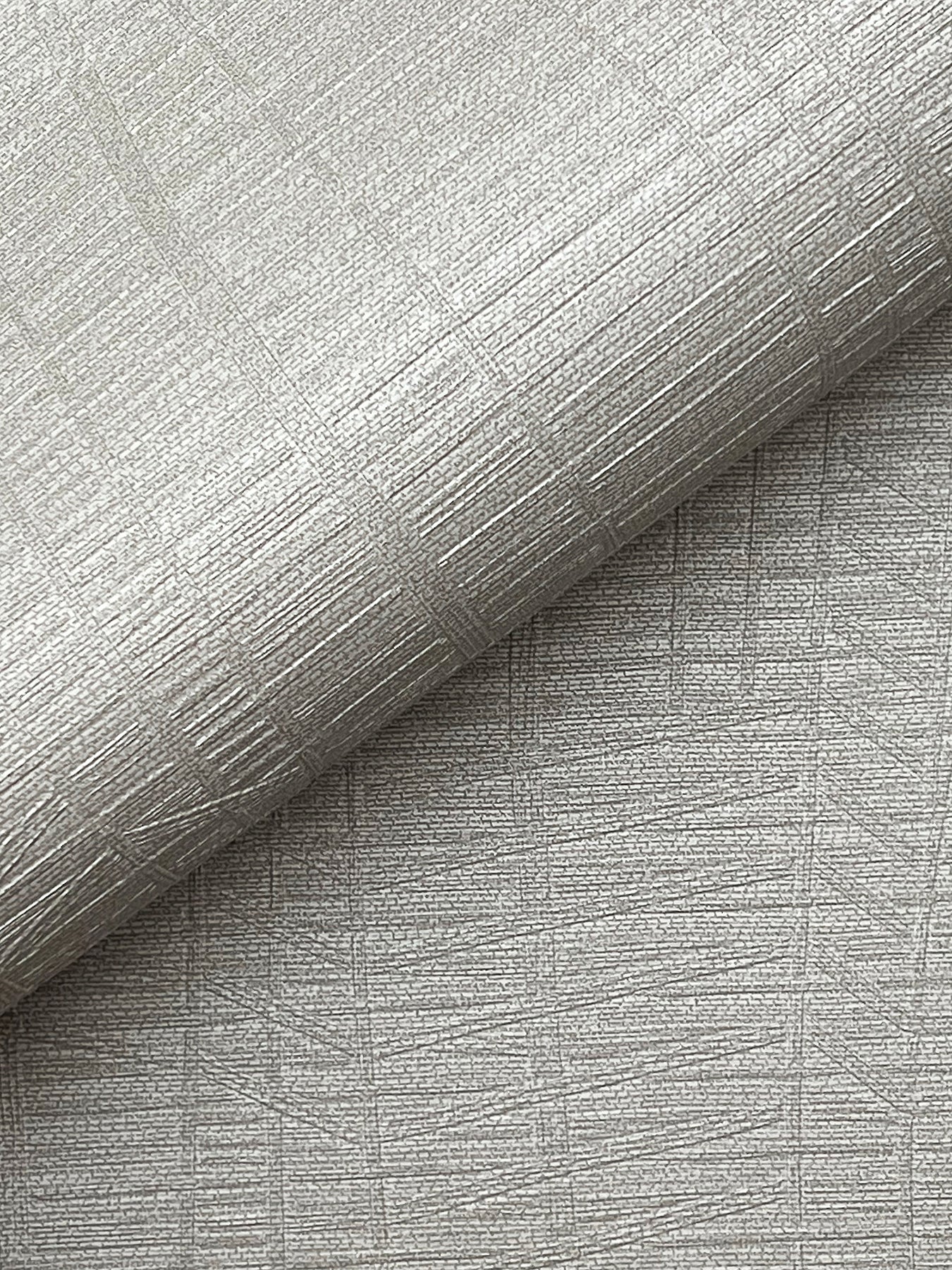 Silver-gray embossed wallpaper with metallic sheen & crosshatched lines; rolled edge.