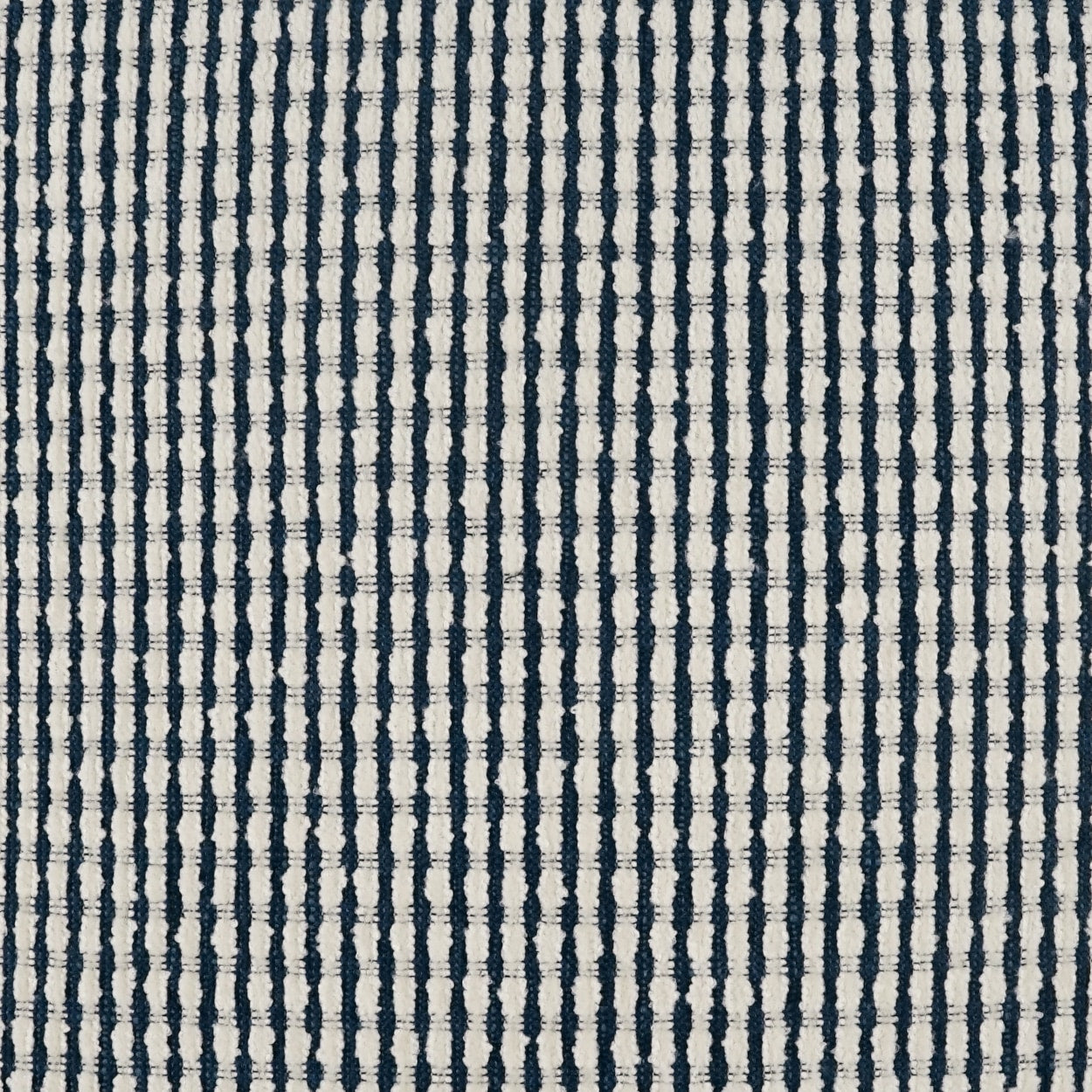 Navy blue striped woven fabric on cream background with slim vertical lines; ideal upholstery or drapery.
