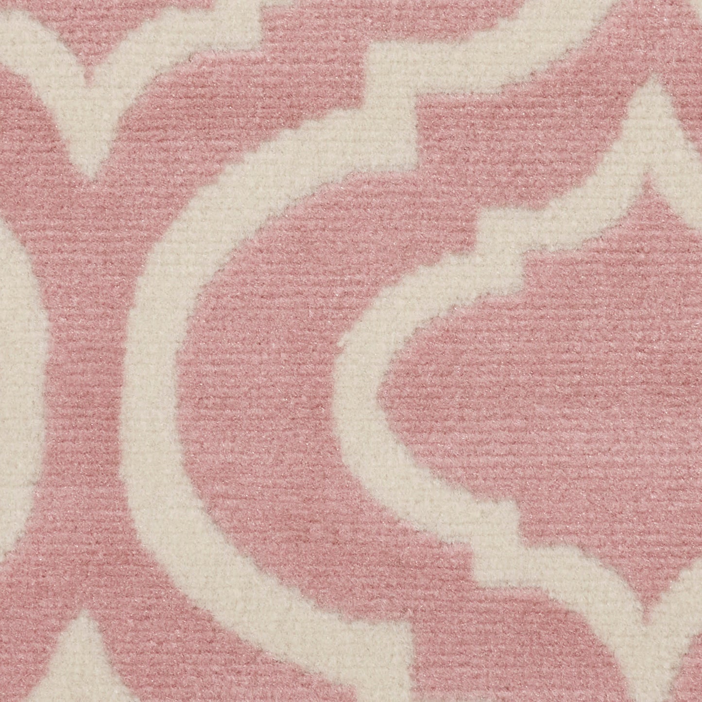 Soft pink rug with ivory scrolling arabesque damask pattern and plush woven texture.