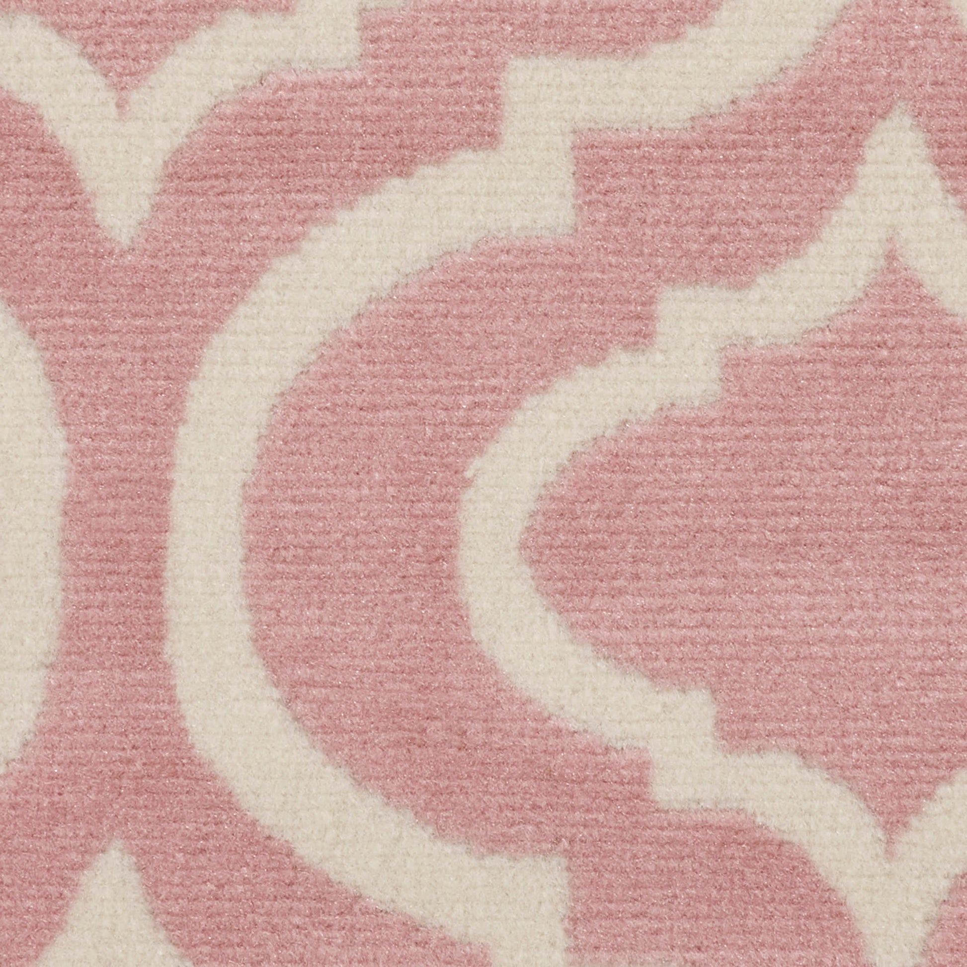 Soft pink rug with ivory scrolling arabesque damask pattern and plush woven texture.