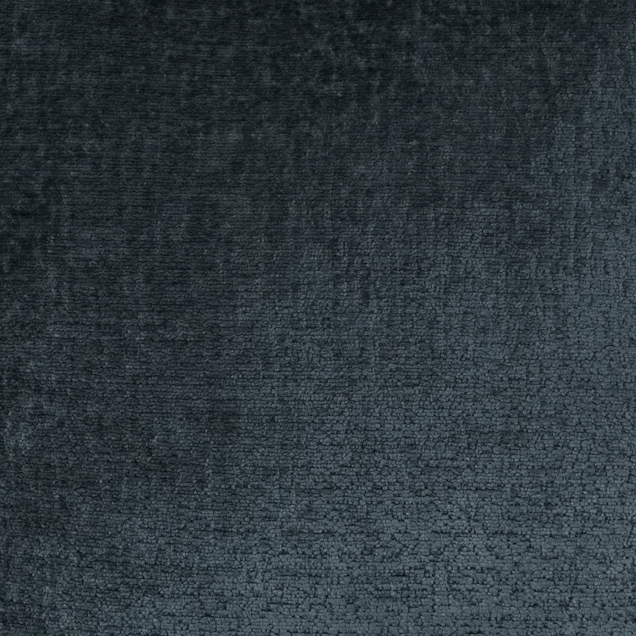 Navy solid textured fabric close-up with soft sheen and plush nap, on a pillow.